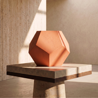 Geometric orange lamp on a concrete surface with a neutral background
